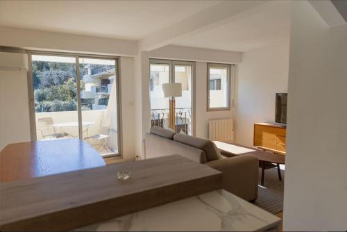 un salon avec un canapé et une table dans l'établissement T2 avec terrasse. Résidence piscine/parking, à Saint-Tropez