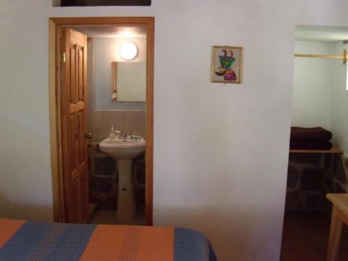 y baño con lavabo, aseo y espejo. en Villa Amacalli, en Tlalpujahua de Rayón