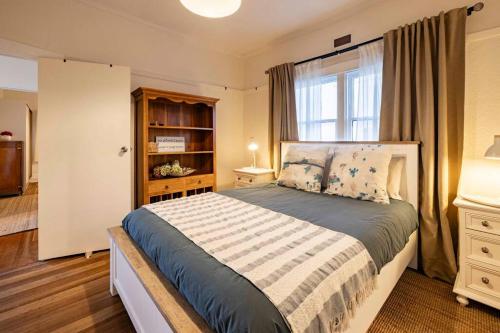 a bedroom with a large bed and a window at Driftaway@Devonport in Devonport