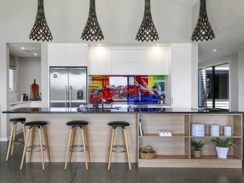 a kitchen with a counter with bar stools at Lake Taupō Luxury Views in Taupo
