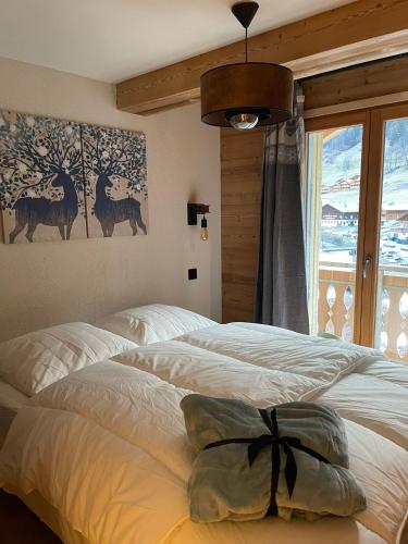 une chambre avec deux lits et une fenêtre dans l'établissement Le Lis, à Châtel