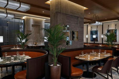 a restaurant with tables and chairs in a room at Waldorf Astoria Doha Lusail in Doha