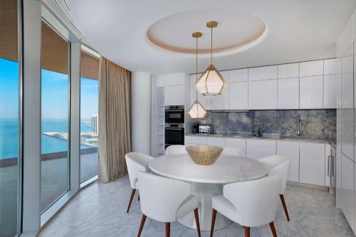 a kitchen with a white table and white chairs at Waldorf Astoria Doha Lusail in Doha