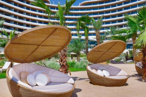 two chairs in the sand in front of a building at Waldorf Astoria Doha Lusail in Doha