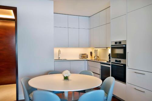 a white kitchen with a table and chairs at Waldorf Astoria Doha Lusail in Doha