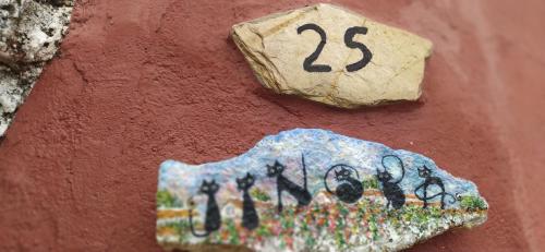 una señal en el costado de una pared con el número en Jinoba25, en Castillo de Bayuela
