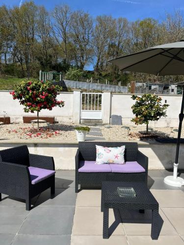 a patio with two chairs and an umbrella at Fogar de Aurora in Portomarin