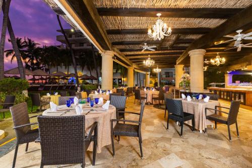 a restaurant with tables and chairs and a chandelier at Villa del Palmar Beach Resort & Spa Puerto Vallarta in Puerto Vallarta