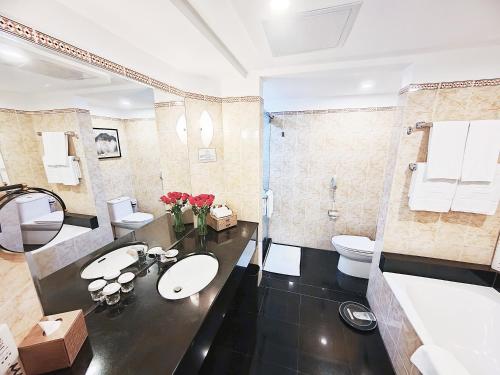 ein Badezimmer mit zwei Waschbecken und einem WC in der Unterkunft Hainan Junhua Haiyi Hotel (Formerly Meritus Mandarin Haikou) in Haikou