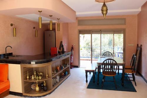 uma cozinha e sala de jantar com mesa e cadeiras em Villa Piscine Privée Jaccuzi em Lalla Takerkoust