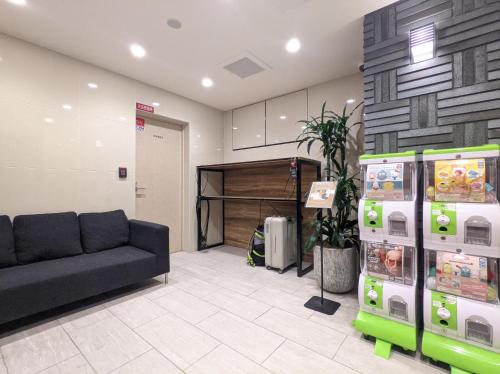 une salle d'attente avec un canapé dans un magasin dans l'établissement ESLEAD HOTEL Osaka Tsuruhashi, à Osaka