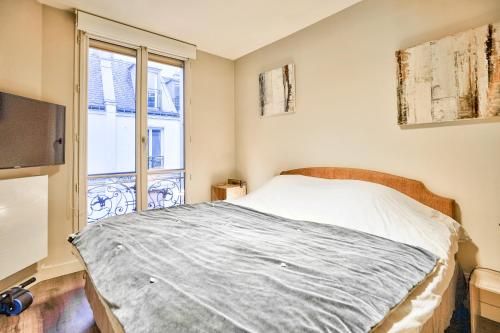 a bedroom with a bed and a window at Trocadéro - Place de Mexico in Paris