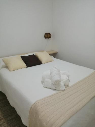 a white bed with towels on top of it at Casa da Romeira in Elvas