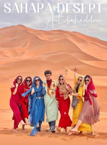 a group of people standing in the desert at Desert Berber Fire Camp in Merzouga