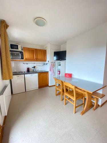 une cuisine avec une table et des chaises dans une pièce dans l'établissement Nice ski nest in Dévoluy, à Saint-Étienne-en-Dévoluy