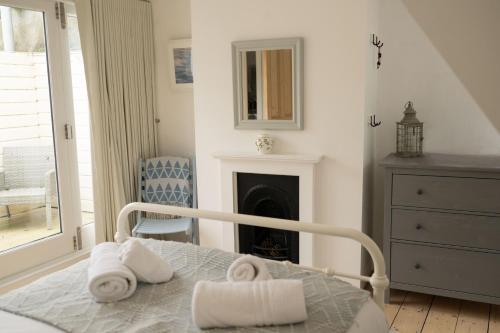 a white bedroom with a bed and a fireplace at Fairhaven in Dartmouth