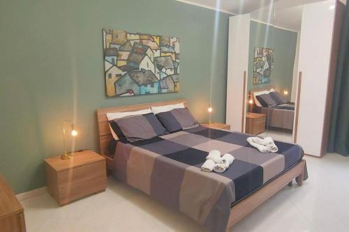 een slaapkamer met een groot bed en 2 handdoeken bij Villa dei Pini con piscina privata in Pietraperzia