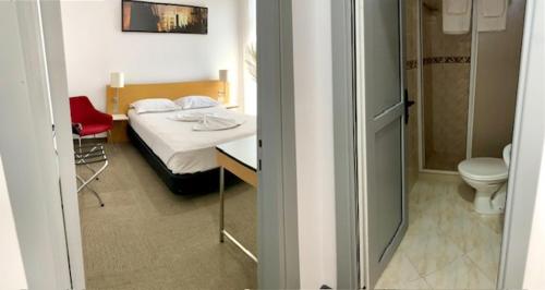 1 dormitorio con 1 cama y baño con aseo en Corso, en Eforie Sud