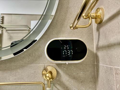 a bathroom with a digital clock on the wall at Heaven Infinity Sunrise Pool & SPA in Mamaia Sat/Năvodari