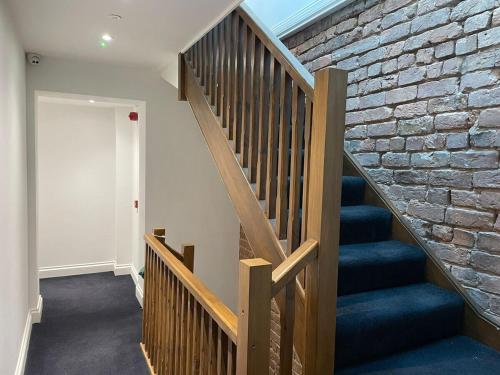 a staircase in a room with a brick wall at The Royal Crest in Liverpool