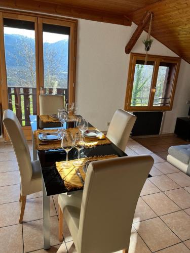 Un comedor con una mesa con copas de vino encima. en Joli T3 à la montagne, en Marignier