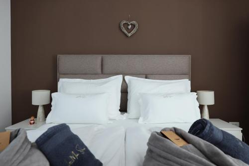 a bedroom with a bed with white sheets and pillows at LA MIA STORIA in Beretinec