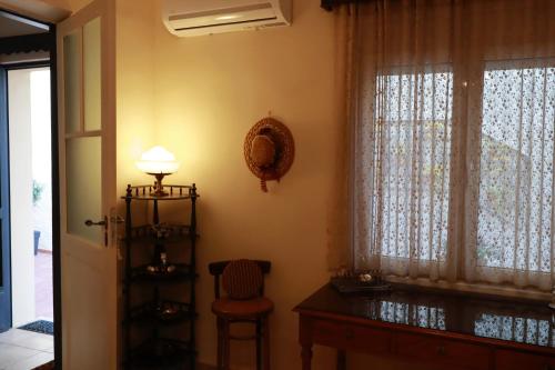 a room with a table and a window and a chair at Orfeas Home/Detached House 74m2,parking&yard in Volos