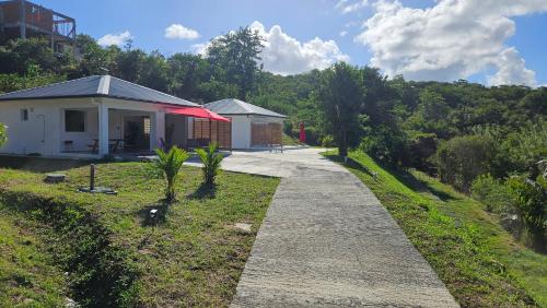 a house on a hill with a walkway in front at Villa Maya & Villa Massaï in Le Marin