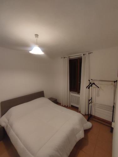 a bedroom with a white bed and a window at Casa a 5 minuti dal centro di Tortona in Tortona