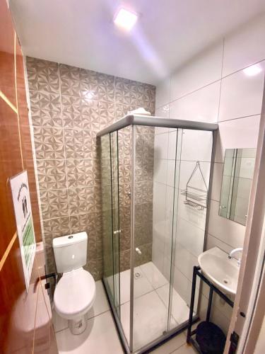 a bathroom with a shower and a toilet and a sink at Princesa Hostel in Belém