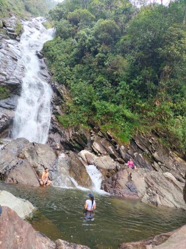 two people in the water in front of a waterfall at Sierra de viboral adventures in Medellín