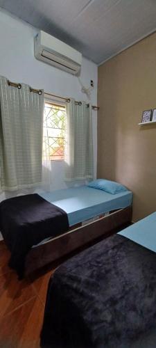 a bedroom with two beds and a window at Hotel Pousada Lagoa Azul in Paranaíba