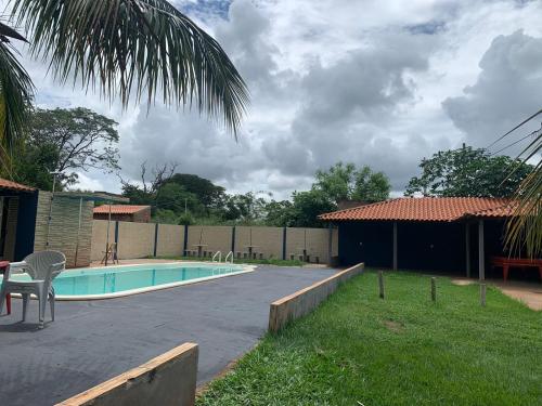 un patio trasero con piscina y una casa en Hotel Pousada Lagoa Azul, en Paranaíba