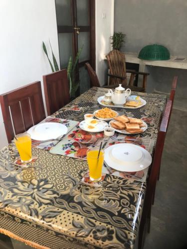 a table with plates of food and drinks on it at yoshen Villa in Unawatuna