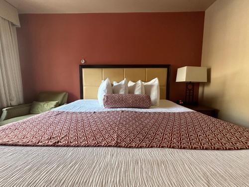 a bedroom with a large bed with a red bedspread at Matterhorn Inn Ouray in Ouray