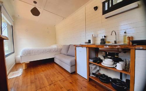 ein Wohnzimmer mit einem Sofa und einem Tisch in der Unterkunft CheTiny Garden - Tiny House en Sierra de los Padres in Sierra de los Padres