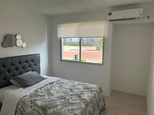 Schlafzimmer mit einem Bett und einem Fenster in der Unterkunft Departamento de Estreno in Candelaria