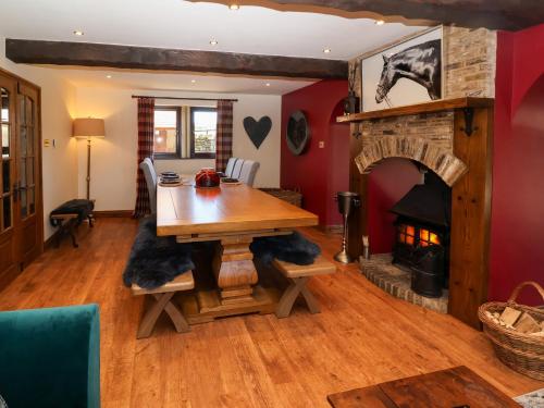 a living room with a wooden table and a fireplace at Farm View Hall in Harrogate