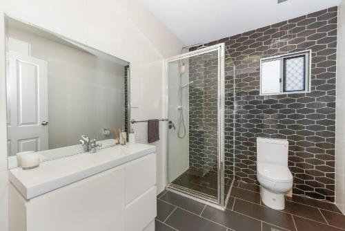 y baño con aseo, lavabo y ducha. en Studio apartment near airport en North Ward