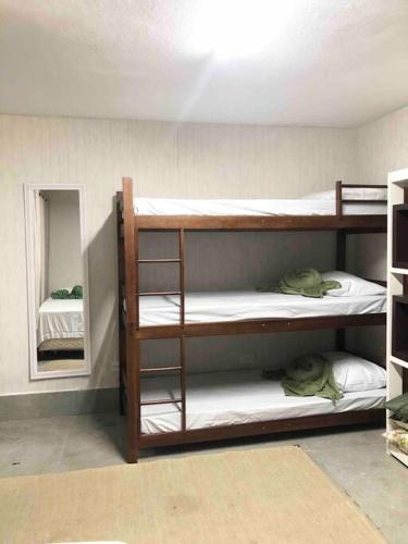 a room with three bunk beds and a mirror at Encontro Open House in São Paulo