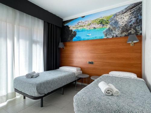 リョレート・デ・マルにあるHotel Maremagnumのベッド2台が備わる客室で、壁には絵画が飾られています。
