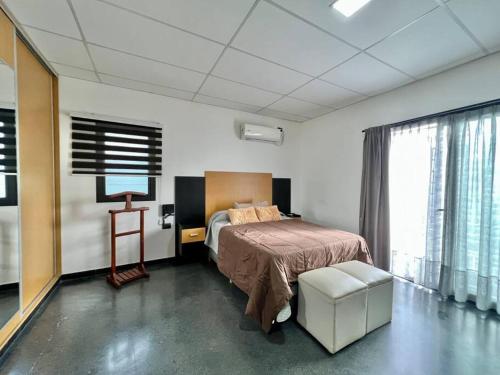 sypialnia z łóżkiem i krzesłem w pokoju w obiekcie Cambacuá Santa Ana! w mieście Villa María