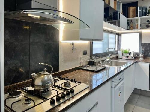 y cocina con fogones y hervidor de agua. en Cambacuá Santa Ana!, en Villa María