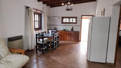 eine Küche und ein Esszimmer mit einem Tisch und einem Kühlschrank in der Unterkunft La Elvira in San Antonio de Areco
