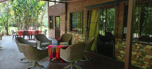 a patio with chairs and a table on a porch at FINCA La PAZ - Sarapiqui in Puerto Viejo