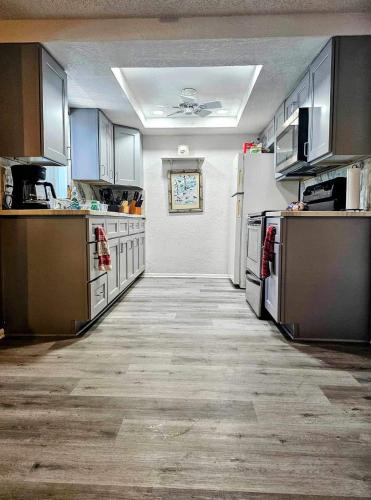 a kitchen with wooden floors and stainless steel appliances at Private Tropical Waterfront Sanctuary w pool, hot tub & an island! Pet Friendly in New Port Richey