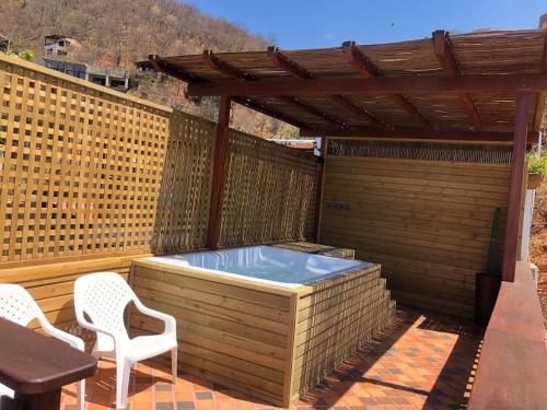 a hot tub on a patio with two chairs at Cabañas Annapurna in Taganga