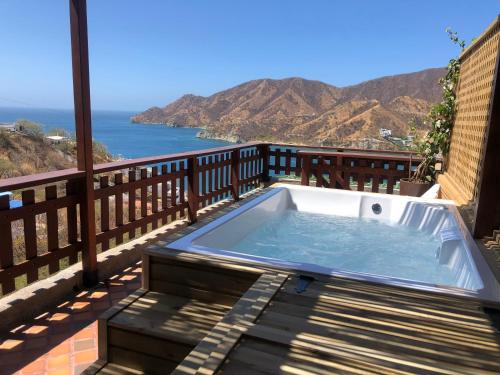 a hot tub on a balcony with a view of the ocean at Cabañas Annapurna in Taganga