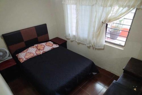 1 dormitorio con cama y ventana en Casa campestre familiar con alberca y areas recreativas, en Totolapan