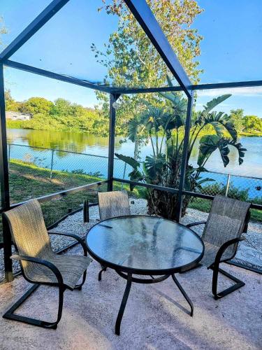 a patio with a table and chairs and a lake at Private Tropical Waterfront Sanctuary w pool, hot tub & an island! Pet Friendly in New Port Richey